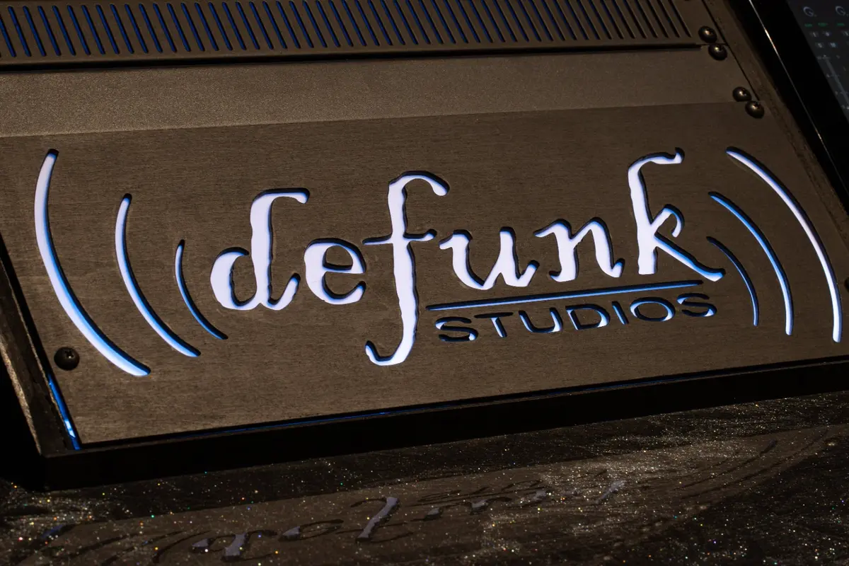 Illuminated Defunk Studios logo built into the production desk